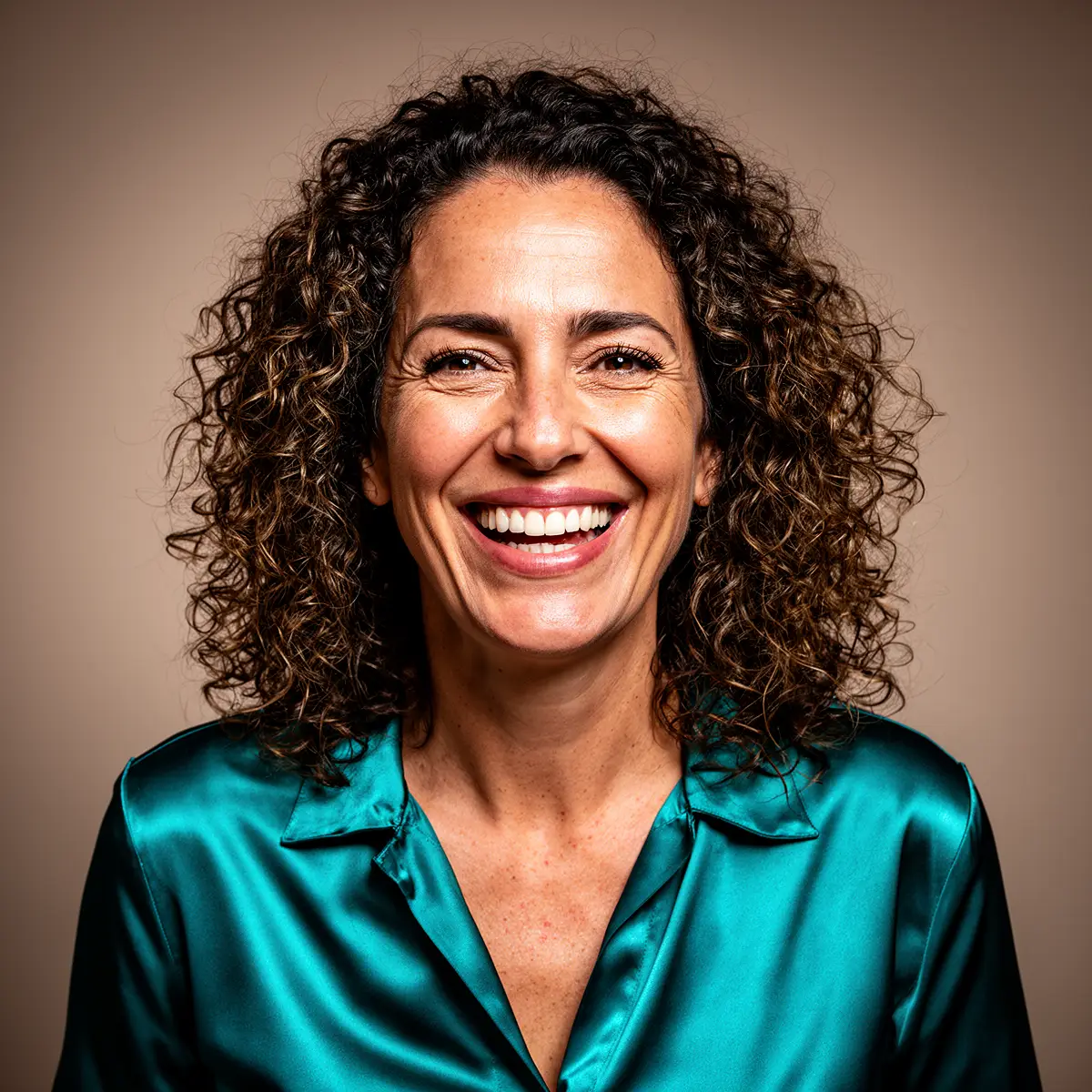 AI-muotimalligeneraattorin tulos RogerApp.ai:ssa: fotorealistinen nainen kiharoilla hiuksilla, sinivihreä satiinipaita, luonnollinen nauru, lämmin beige studiotausta